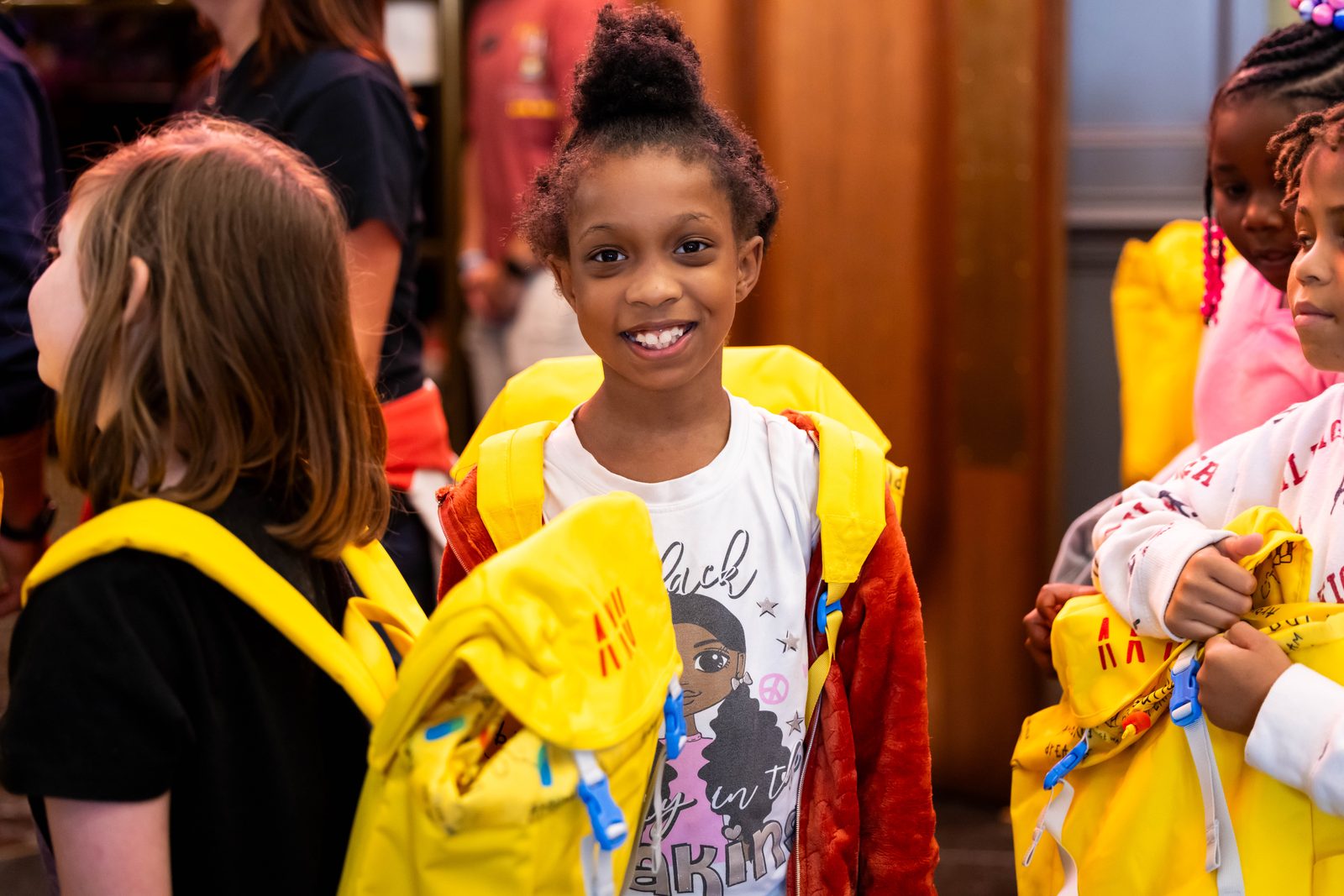 Kids smiling with their yellow Aku backpacks